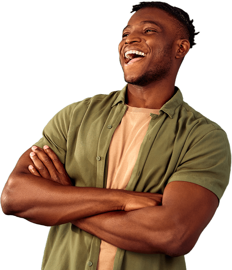 A man in a grey collared t shirt with his arms folded grinning